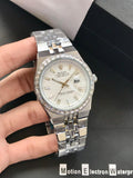 Silver wristwatch with detailed face held by a hand on a dark background
