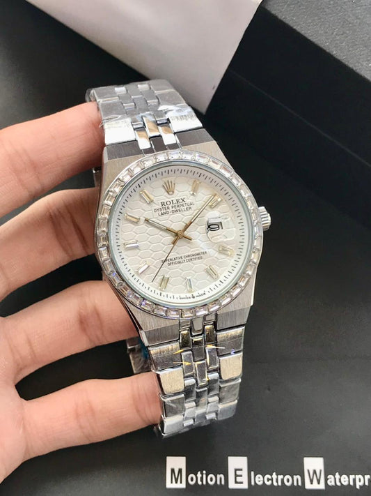 Silver wristwatch with detailed face held by a hand on a dark background