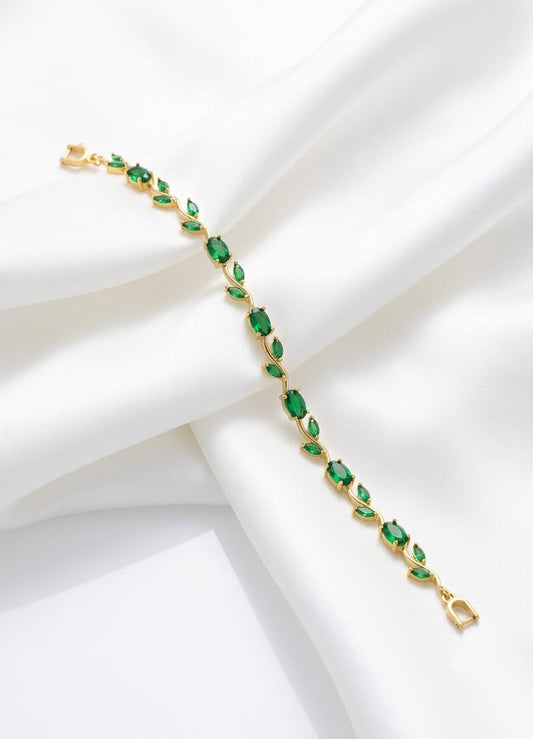 Gold bracelet with green gemstones on a white background